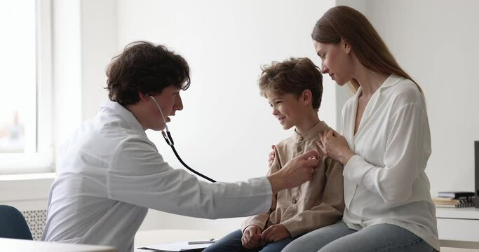 Pediatrician holds stethoscope check little child lungs sounds or heart beat after disease feel satisfied with health test result show thumbs up to patient and mom at clinic visit. Pediatric, medicine
