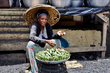 A woman sells okra by the roadside - obrazy, fototapety, plakaty