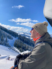 man on ski lift in sun, austria