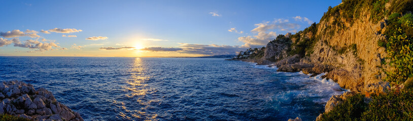 Fototapeta na wymiar Beautiful sunset over the sea near the mountains in Nice, France. Calm seascape, panorama.