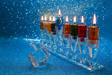 Jewish holiday Hanukkah background with menorah and dreidel with letters Gimel and Nun.