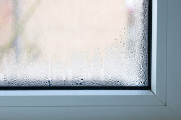 Close up of double glazed window  condensation causes by excessive moisture in the house in winter occurs when the seal between panes is broken or desiccant inside the window. - obrazy, fototapety, plakaty