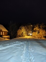 house with lights in the windows and snow everything around 