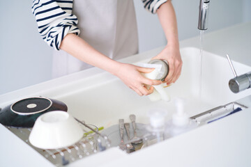 キッチンでお皿を洗う女性