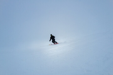 a skier during a snowfall descends at great speed down the mountain