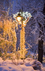 Lantern in the park in the evening covered with snow.