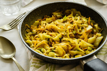 Frypan with sautéed fennel with orange. Traditional French dish. Fennel, pine nuts and orange