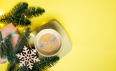 cozy new year layout with a cup of coffee and new year decorations and christmas lights on a yellow...