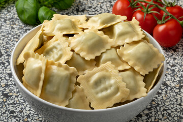 Bowl with traditional fresh Italian raviolini stuffed with Basilicum and Provolone close up 