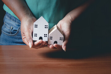 Woman's hand with a small house in hand, vintage style.
