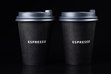 two black paper coffee cup isolated on black background