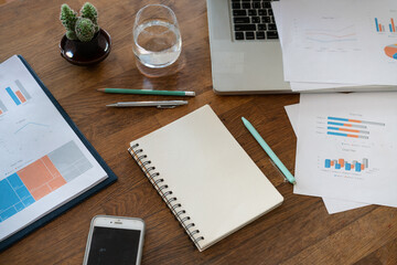 Non people imagery of desk set-up , work environments . work at a desk in a home office. .Writing on a notepad while working from home.