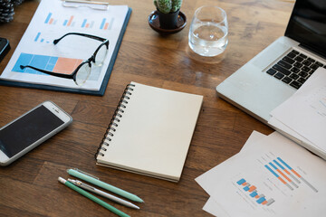 Non people imagery of desk set-up , work environments . work at a desk in a home office. .Writing on a notepad while working from home.