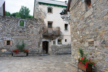 Old white village house that joins the gray stone house next door creating an artistic effect
