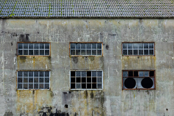Abandoned factory walls background with broken windows