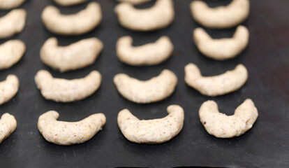 A woman is baking vanilla-flavoured crescent cookies