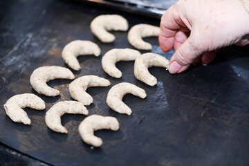 A woman is baking vanilla-flavoured crescent cookies