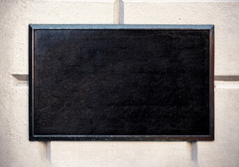 Blank black and white concrete wall. Blank black sign plate on textured wall. Mockup of a plate metal sign