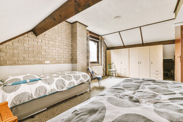 a bedroom with a bed, dressers and tv in the corner on the left side of the room is an old brick...