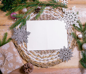 white paper with space for text on wooden ground with christmas ornaments, fir branches and christmas balls