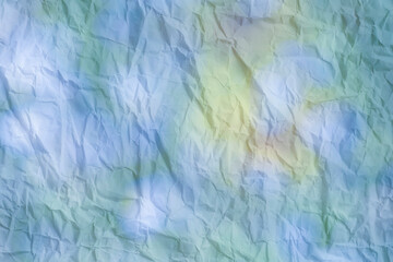 Crumpled paper with colorful spots as a background.