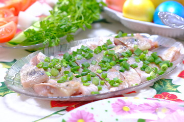 Ukrainian Easter festive dishes. Festive table setting. Bright colored eggs, cake Paska, traditional salad olivier, fried fish, sandwiches with red caviar, vegetables, green, homemade sausage, herring