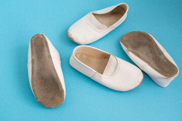 children's white dancing shoes on a blue background. Children's Ballet