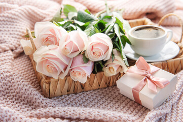Obraz na płótnie Canvas Tray with bouquet of beautiful pink roses and gift box on bed.