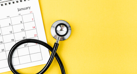 Top view of stethoscope medical and calendar with empty space on the yellow background, schedule to check up healthy concepts.
