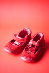 children's shoes on red color background 