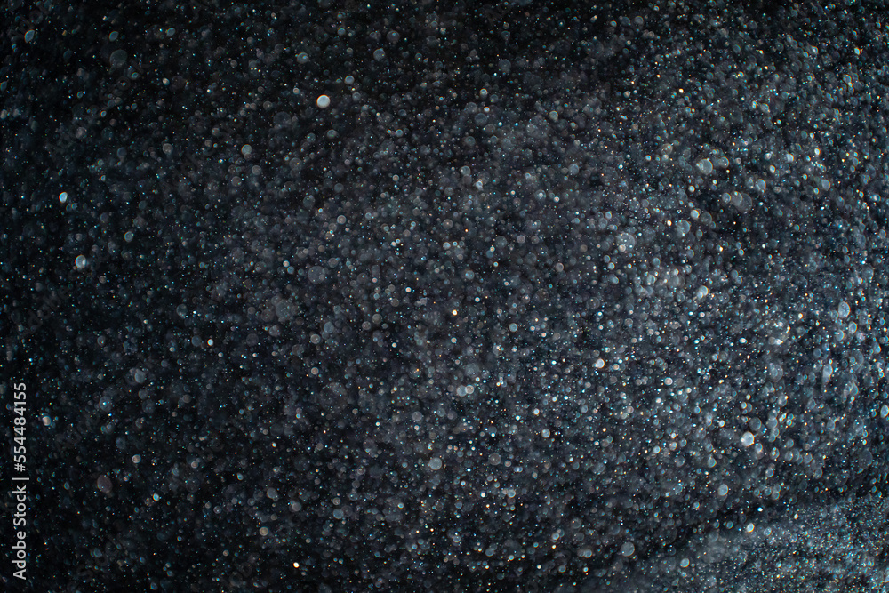 Wall mural abstract real dust particles on black background. glittering sparkling bokeh overlay design with cop