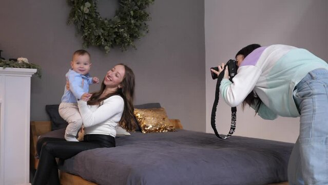 Photo shot session for young mother with small baby son child on a sofa with professional photographer