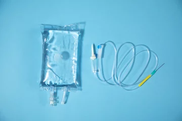 Fotobehang  Infusion bag in the blue background. IV drip chamber © andranik123