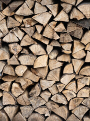 Dry firewood stacked in a pile, chopped wood for winter heating fuel of the fireplace. Natural wood background.