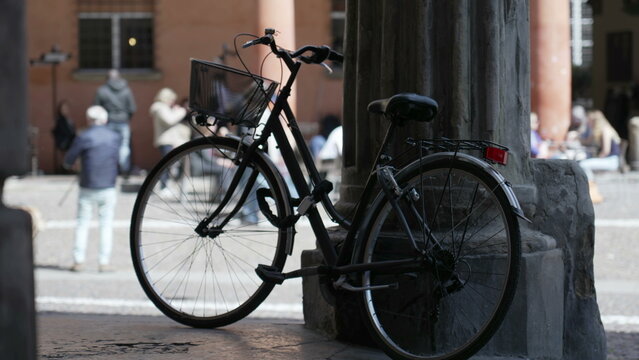 Bicycle leaning on old European column. Bike parked outside. Urban alternative transportation