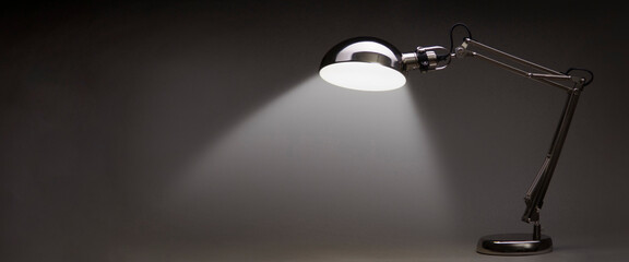 Illuminated Vintage black desk lamp isolated on black