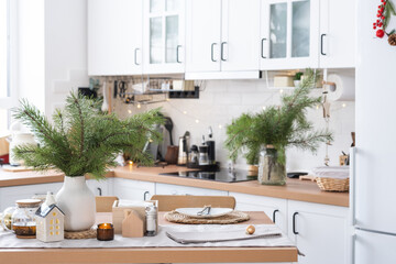 Festive Christmas decor in white kitchen, festive breakfast, white scandi interior. The figure of a cozy house ion the set table. New Year, mood, cozy home. Copy space