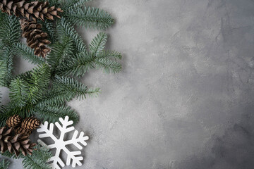Christmas composition. Christmas decorations, pine cones, fir branches on gray stone background.
