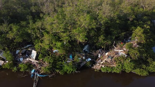 Debris from Hurricane Ian litters the waters of Fish Trap Bay on Bonita Beach, FL