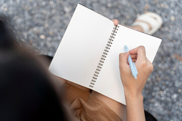 Side view of young woman concentrated drawing on her notebook while enjoying