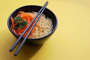 vegetarian ramen noodles with chopsticks on yellow background 