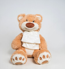 Teddy bear with a bow on a white background. Soft children's toy.