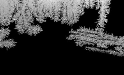 Frost pattern on glass, black background.