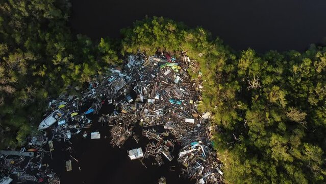 Debris from Hurricane Ian litters the waters of Fish Trap Bay on Bonita Beach, FL