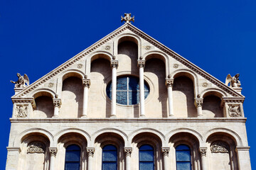 Fototapeta premium stone church elevation detail in roman style. old religious architecture concept. cathedral facade in Pecs, Hungary. statues and ornaments. travel and tourism.
