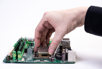 Engineer repairman holding hands in black gloves chip processor, CPU to insert into the socket of the computer motherboard. The concept of technology hardware in the neon light