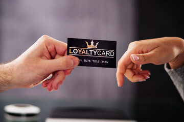 Businessman's Hand Giving Loyalty Card