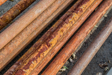 Old rusty water pipes in a pile