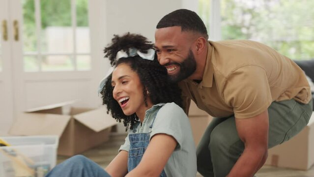 Black couple, moving and new house while happy, excited and playful while in cardboard box for fun while unpacking. Man and woman excited as home owners after mortgage or loan approval for property