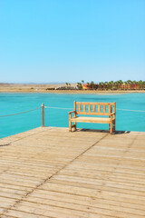 Empty bench at a sea pier, summer vacation concept.